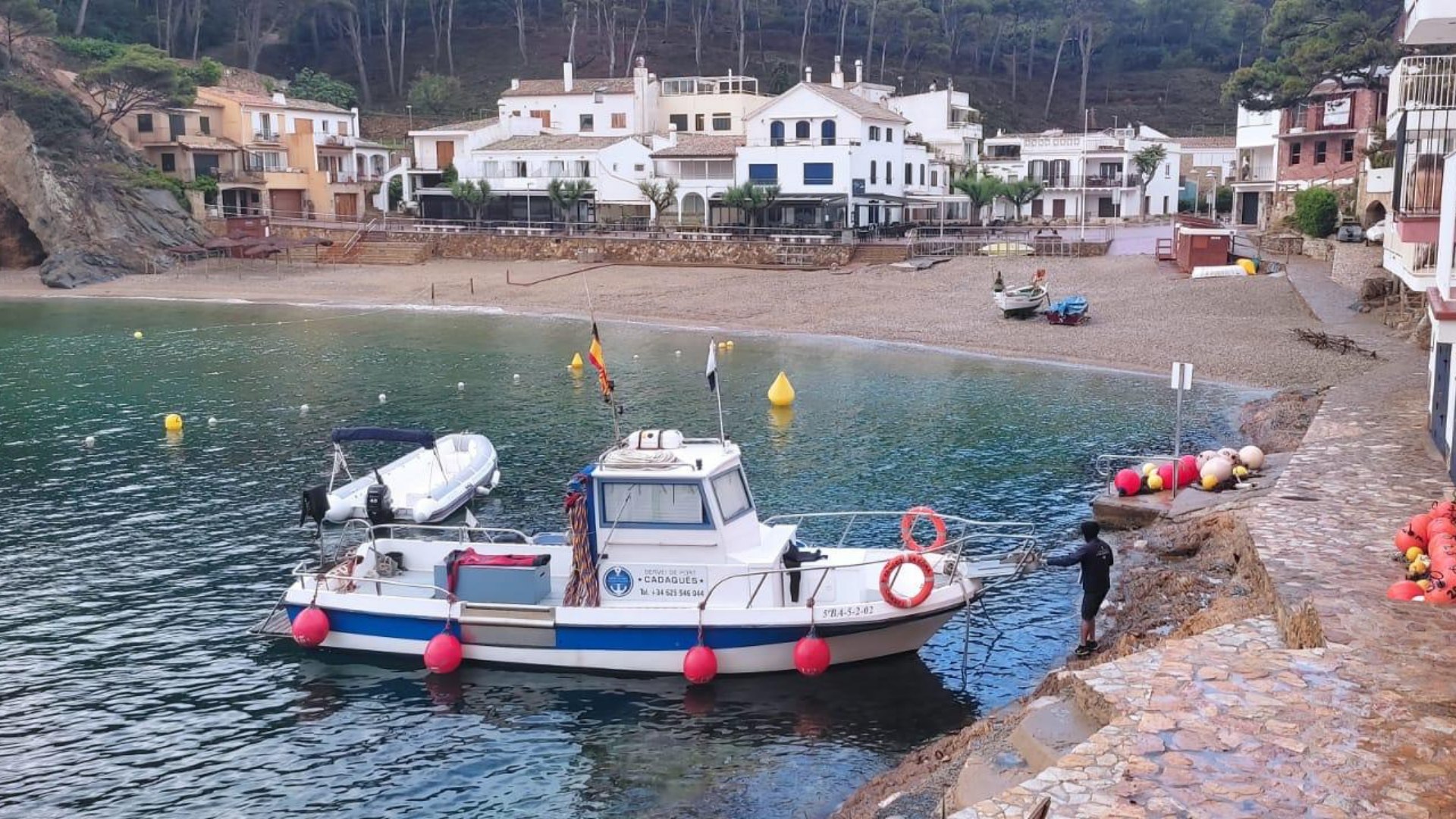 Barca de servei SP Cadaqués amb boies d'amarratge a la badia